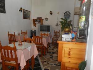 a dining room with tables and chairs and a tv at Blue Sky in Kokkari