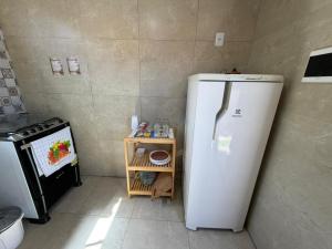 a kitchen with a white refrigerator and a stove at Brisa da Mata Suítes BF quarto 02 in Baía Formosa +9 photos