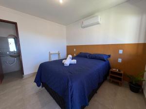 a bedroom with a bed with a stuffed animal on it at Brisa da Mata Suítes BF quarto 02 in Baía Formosa