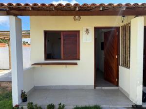 a house with a door and a window at Brisa da Mata Suítes BF quarto 02 in Baía Formosa