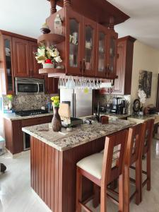 a kitchen with wooden cabinets and a granite counter top at Caribbean Luxury Penthouse in San Felipe de Puerto Plata +22 photos