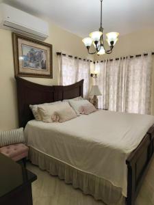 a bedroom with a large bed and a chandelier at Caribbean Luxury Penthouse in San Felipe de Puerto Plata