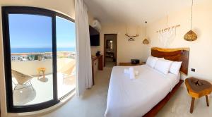 a bedroom with a white bed and a large window at Hotel Boutique Alcalá Vallarta in Puerto Vallarta