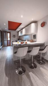 a kitchen with a counter and some chairs in it at NURAS - Casa degli Anemoni in Porto Conte +22 photos