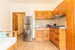 a kitchen with wooden cabinets and a stainless steel refrigerator at Chango's Apartments in Bocas Town