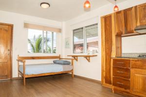 a bedroom with a bed and a window and a kitchen at Chango's Apartments in Bocas Town
