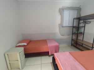 a small bedroom with two beds and a window at Casa Prox Centro in Ribeirão Preto