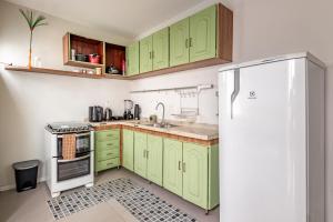 a kitchen with green cabinets and a refrigerator at Casa e Suíte Brisa do Bosque in Belém