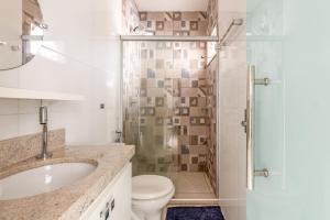 a bathroom with a shower and a toilet and a sink at Casa e Suíte Brisa do Bosque in Belém