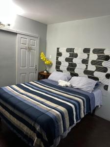 a bedroom with a bed with a blue and white striped blanket at Diamond Palace in Kingston