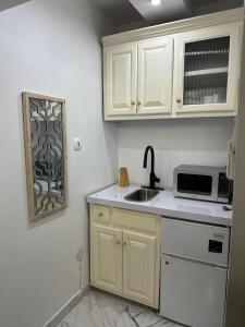 a kitchen with white cabinets and a sink and a microwave at Diamond Palace in Kingston