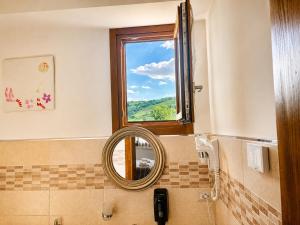 a bathroom with a mirror and a window at La Fontanella in Montecchia di Crosara +43 photos