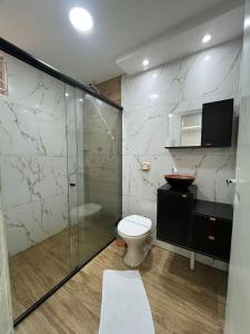 a bathroom with a toilet and a glass shower at Maxi Palace hotel in Capitão Leônidas Marques +51 photos