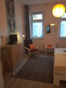 ヴィスマールにあるAltstadt Fairmietungのベッド、テレビ、椅子が備わる客室です。