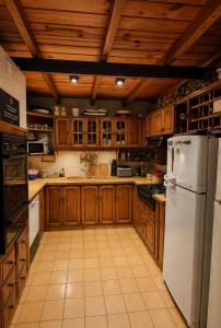 eine Küche mit Holzschränken und einem weißen Kühlschrank in der Unterkunft Casa 45 in San Martín de los Andes + 48 Fotos