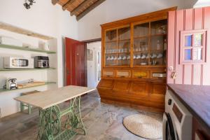 a kitchen with a table and a wooden cabinet at Horta dos Cismeiros, Monsaraz - Monte Alentejano com Piscina in Monsaraz