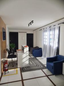 a living room with a couch and a table and chairs at Pousada Recanto da Enseada in Cabo de Santo Agostinho