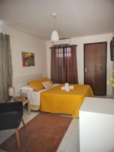 a bedroom with two beds with yellow sheets at Pousada Recanto da Enseada in Cabo de Santo Agostinho +88 photos