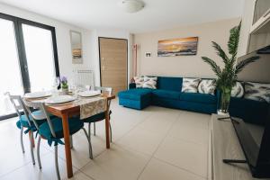 a living room with a table and a blue couch at Athena Garden House in Montesilvano
