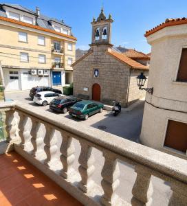 a balcony of a building with cars parked in a parking lot at APARTAMENTOS LA CAPILLA in Villanueva de Arosa