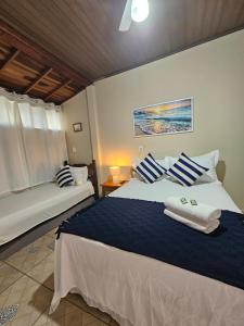 a bedroom with two beds with blue and white pillows at Flat Sol Paraty in Paraty