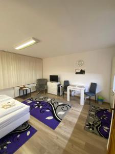 a room with a bed and a desk and chairs at Apartmán Hollého 2 in Trenčín