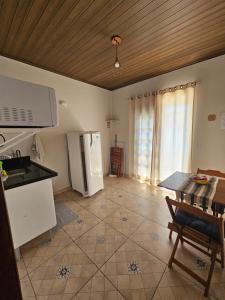 a kitchen with a refrigerator and a table at Flat Sol Paraty in Paraty
