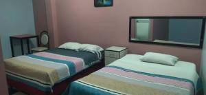 a small bedroom with two beds and a mirror at Hospedaje LA RESIDENCIA in Ayacucho