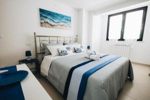 a bedroom with two beds with blue and white sheets at Athena Garden House in Montesilvano