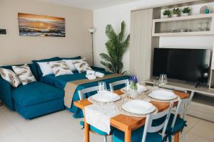 a living room with a blue couch and a table at Athena Garden House in Montesilvano