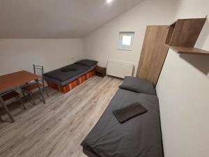 a small room with two beds and a table at Penzión Poloniny in Ulič