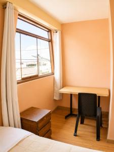 a bedroom with a desk and a window at Imasmari Wasi in Pisac