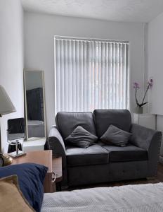 a living room with a couch in front of a window at Dream easy in Birmingham