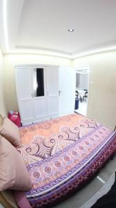 a bed in a room with a blanket on it at Appartement Aokas Béjaïa in Aokas