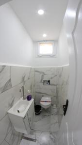 a white bathroom with a sink and a toilet at Appartement Aokas Béjaïa in Aokas