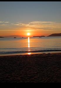 a sunset on the beach with the sun setting at Flat Sol Paraty in Paraty