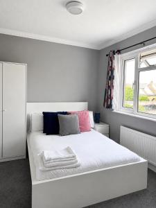 a white bed in a room with a window at 3-Bedroom House ,Quiet & Spacious in Kent