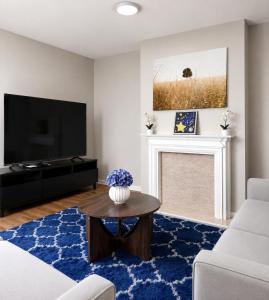 a living room with a tv and a blue rug at 3-Bedroom House ,Quiet & Spacious in Kent