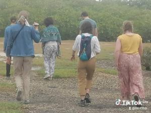 a group of people walking down a path in the rain at Villa de luxe Palmarin in Palmarin