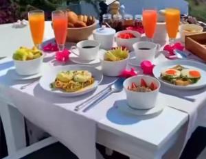 a white table with plates of food and drinks at Villa de luxe Palmarin in Palmarin