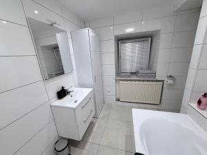 a white bathroom with a sink and a mirror at Eliasar2 in Linz