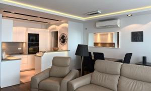 a living room with a couch and a table and a kitchen at Vijolie West Exclusive in Warsaw