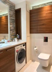 a bathroom with a washing machine and a sink at Vijolie West Exclusive in Warsaw +15 photos