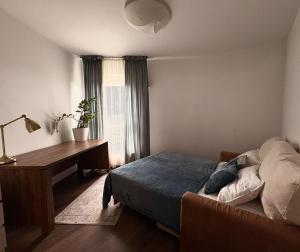 a bedroom with a bed and a desk and a window at Vijolie West Exclusive in Warsaw