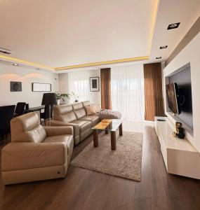 a living room with a couch and a tv at Vijolie West Exclusive in Warsaw