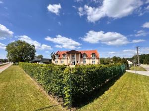 a house behind a hedge with a fence at Moravian Garden House Novosedly Adults Only in Novosedly