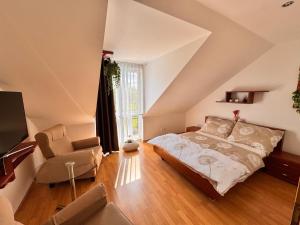 a attic bedroom with a bed and a chair at Moravian Garden House Novosedly Adults Only in Novosedly