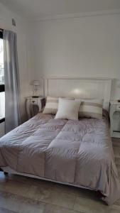 a bed in a bedroom with a white wall at Monoambiente 4 de enero in Santa Fe