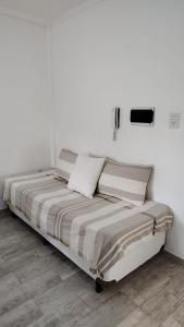 a bed in a room with white walls at Monoambiente 4 de enero in Santa Fe
