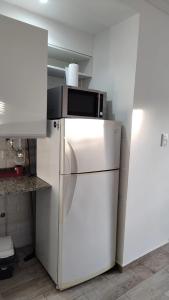 a microwave on top of a refrigerator in a kitchen at Monoambiente 4 de enero in Santa Fe
